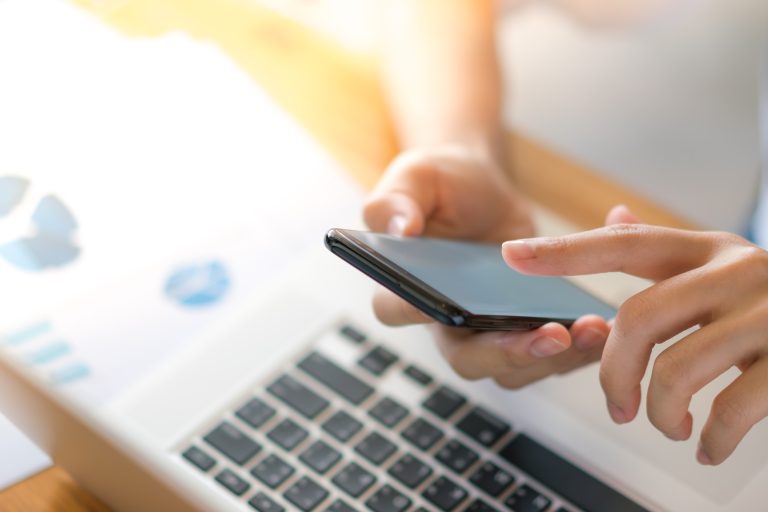 Cuánto cuesta enviar SMS masivos en México: qué incluye el precio y qué lo encarece Persona revisa en su teléfono y su laptop el gasto de sus campañas de SMS
