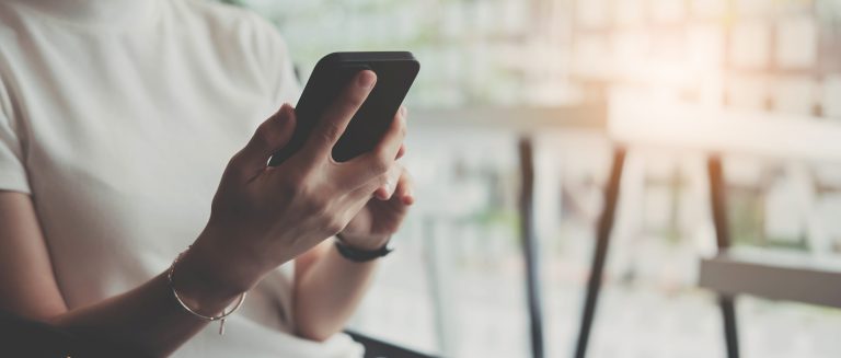 Manos de una mujer escribiendo un código de verificación en su celular