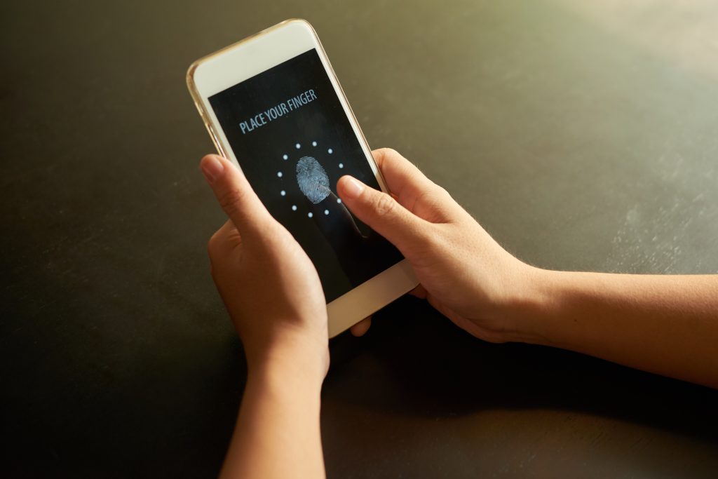 Mano sostiene un celular con la pantalla de identificación y acceso