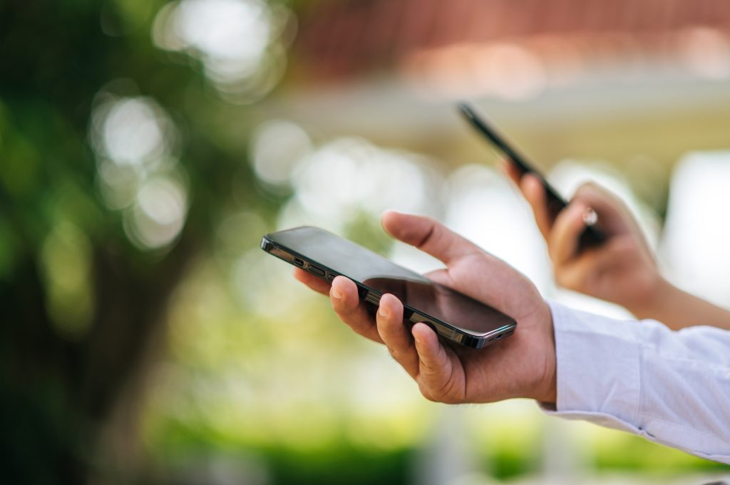 Cuántos caracteres tiene un SMS: GSM7, UCS-2, acentos, emojis y segmentos explicados Mano masculina sostiene un smartphone