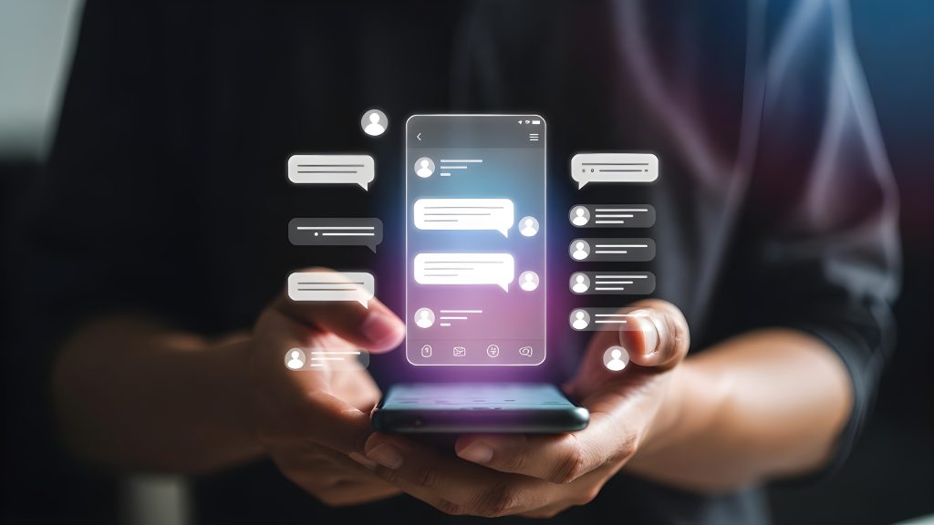 Persona sostiene un smartphone con una aplicación de chat y notificaciones
