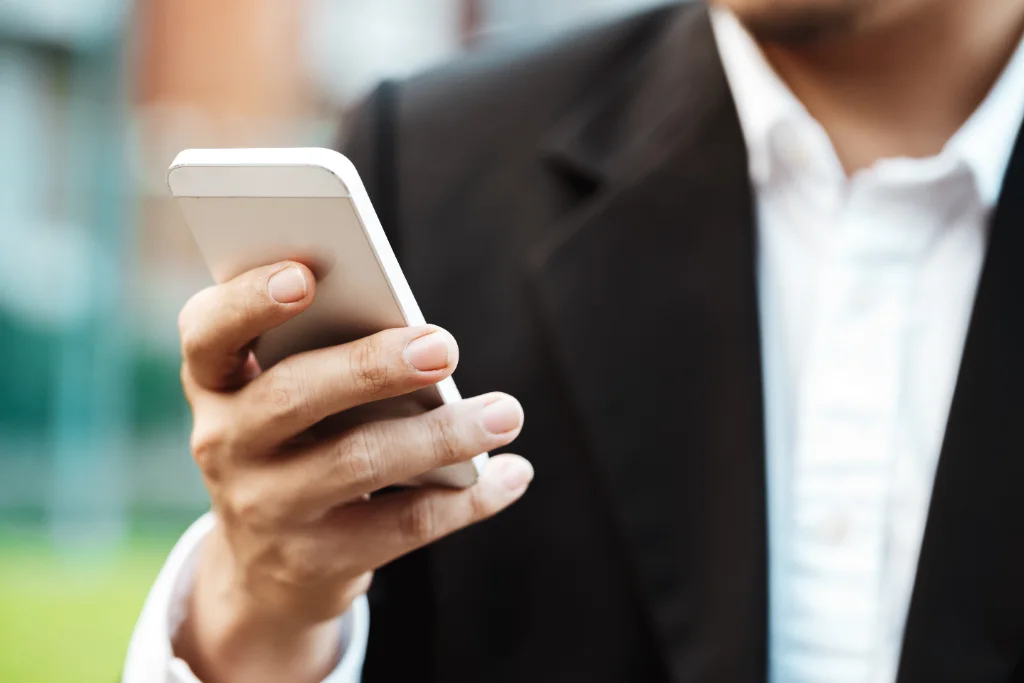 Profesional escribiendo un mensaje SMS en su smartphone