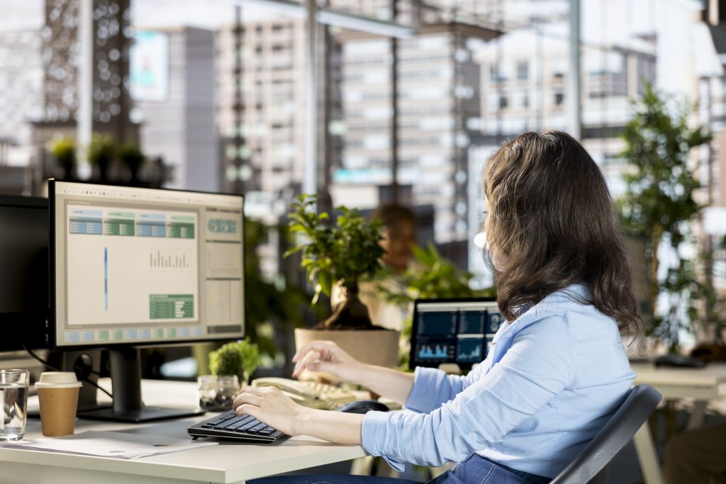 Cómo enviar SMS masivos desde un archivo de Excel o CSV sin programar Empleada revisando datos en la pantalla de su computadora